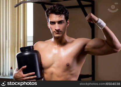 Man with nutrient supplements in sports gym