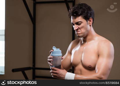 Man with nutrient supplements in sports gym