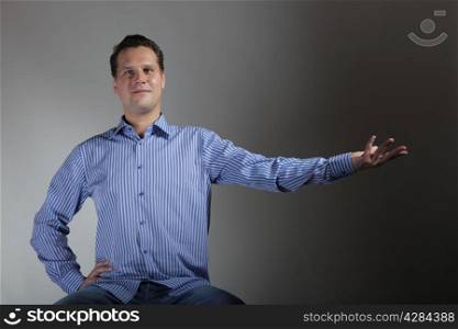 man with open empty palm hand hesture copy space for product on gray background. Concept of holding or giving