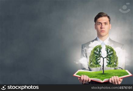 Man with opened book. Businessman open book with growing tree concept on pages