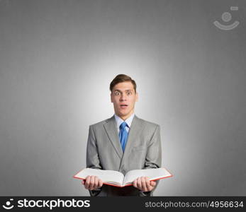 Man with opened book. Young businessman holding in hands blank opened book