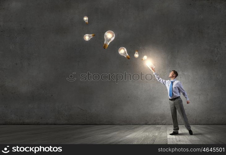 Man with opened book. Young screaming businessman on pile reaching hand with opened book and light bulb flying out