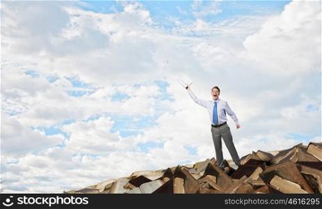 Man with opened book. Young screaming businessman on pile reaching hand with opened book