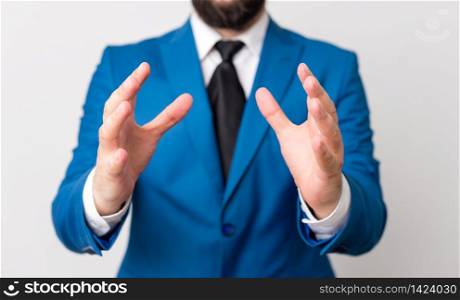 Man with opened hands in fron of the table. Mobile phone and notes on the table.. Man with opened hands in fron of the table. Mobile phone and notes on the table. Business concept with man in the suite.
