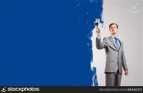 Man with paint brush. Young businessman with paint brush in hand