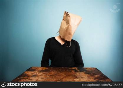 Man with paper bag over his head is sad