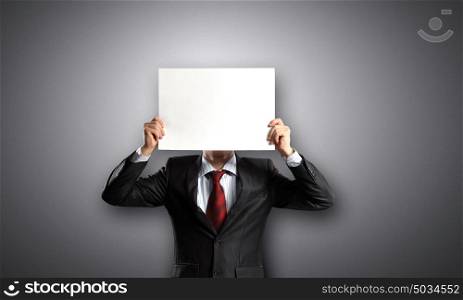 Man with paper sheet. Unrecognizable businessman hiding face behind blank paper sheet