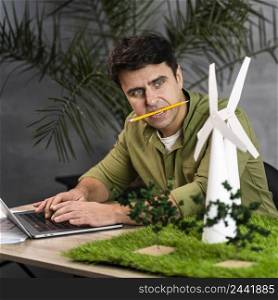 man with pencil his mouth working eco friendly wind power project