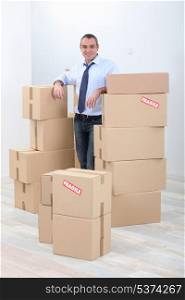 Man with piles of cardboard boxes marked fragile