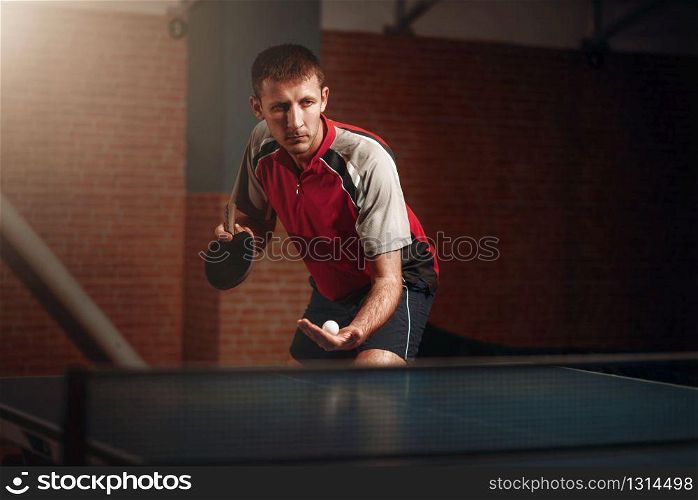 Man with racket in action, playing table tennis. Ping pong training, high concentration sport. Man with racket in action, playing table tennis