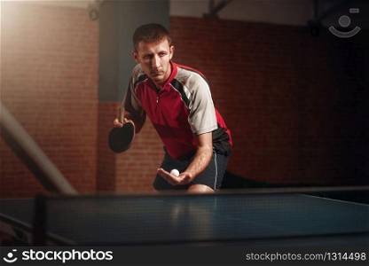 Man with racket in action, playing table tennis. Ping pong training, high concentration sport. Man with racket in action, playing table tennis