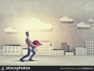 Man with red bag. Young man in casual carrying heavy red bag