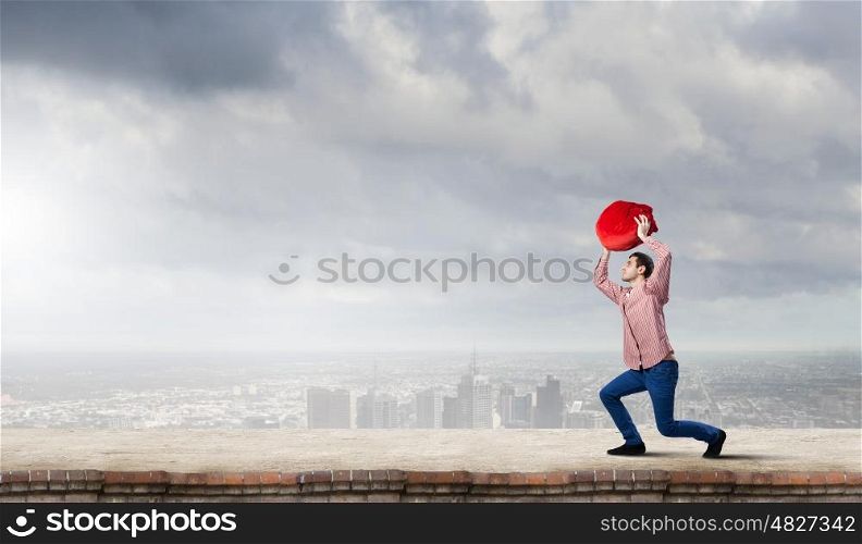 Man with red bag. Young man in casual carrying heavy red bag