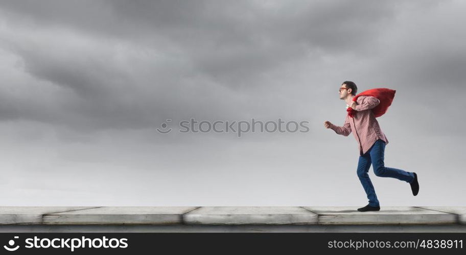 Man with red bag. Young man in casual carrying heavy red bag