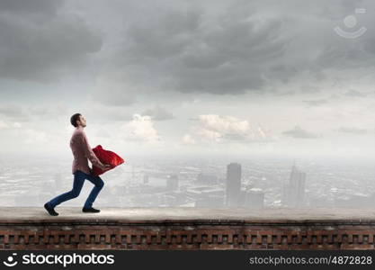 Man with red bag. Young man in casual carrying heavy red bag