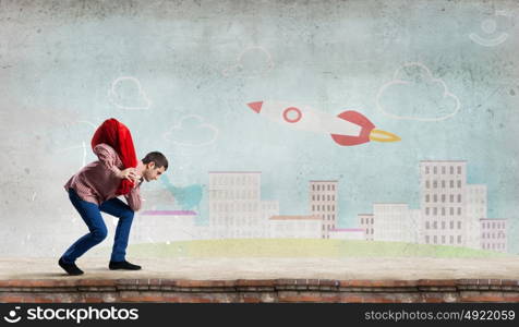 Man with red bag. Young man in casual carrying heavy red bag