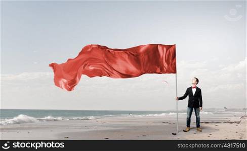 Man with red waving flag. Student guy in casual with red flag in hands