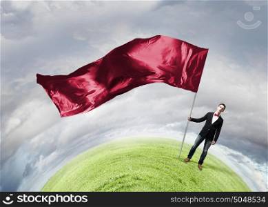Man with red waving flag. Student guy in casual with red flag in hands