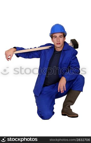 Man with sledge-hammer kneeling