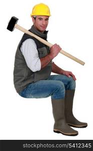 Man with sledge-hammer sat on stool