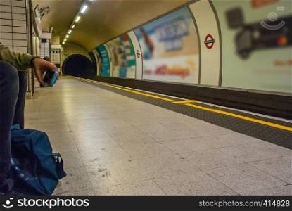 man with smart phone at train Leicester square station in London.