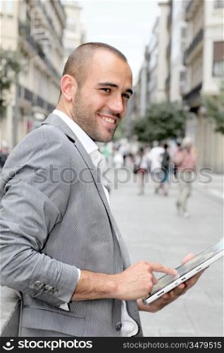 Man with suit jacket using touchpad in town