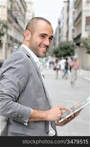 Man with suit jacket using touchpad in town
