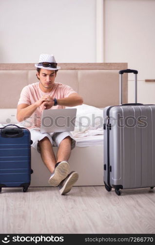 Man with suitcase in bedroom waiting for trip 