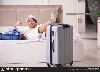 Man with suitcase in bedroom waiting for trip 