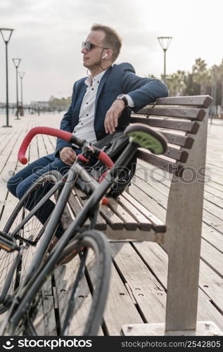 man with sunglasses sitting bench his bike 2