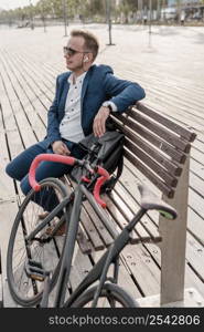 man with sunglasses sitting bench his bike