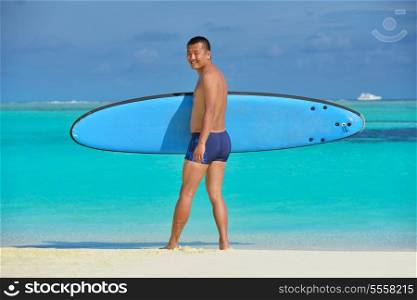 Man with surf board on beautiful tropical beach beach