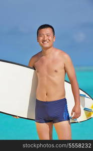 Man with surf board on beautiful tropical beach beach