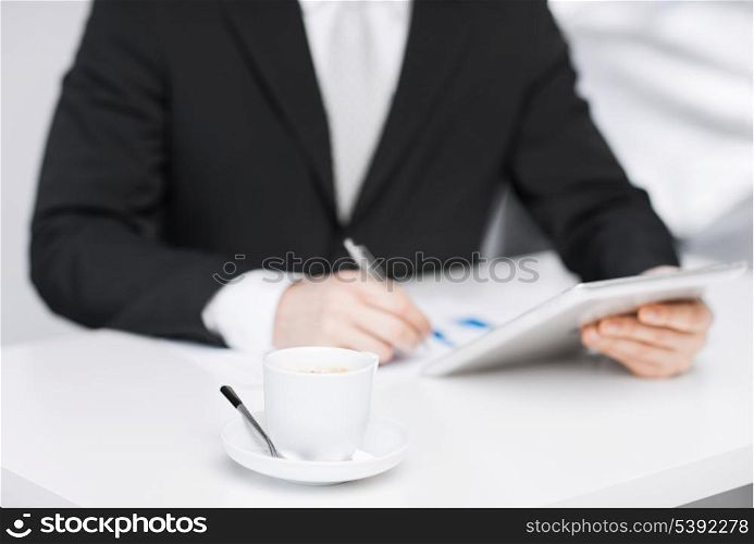 man with tablet pc, cup of coffee and graphs