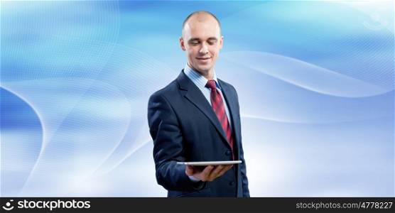 Man with tablet pc. Young handsome businessman holding tablet pc in hand