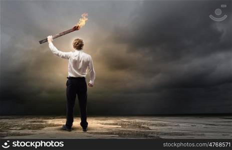 Man with torch. Young businessman holding burning torch in hand