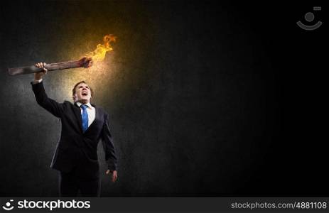 Man with torch. Young businessman holding burning torch in hand