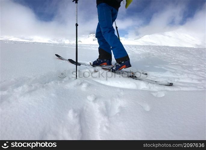 man with touring ski climbing mountain in fresh snow