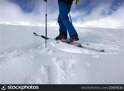 man with touring ski climbing mountain in fresh snow