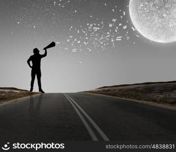 Man with trumpet. Silhouette of man at night screaming in megaphone