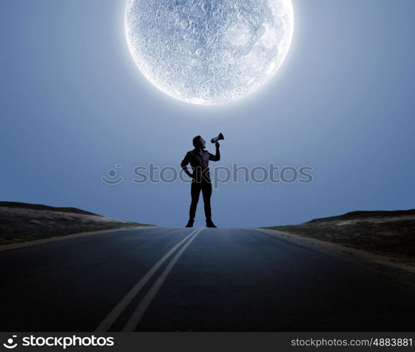 Man with trumpet. Silhouette of man at night screaming in megaphone