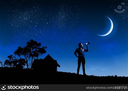 Man with trumpet. Silhouette of man screaming in trumpet at night
