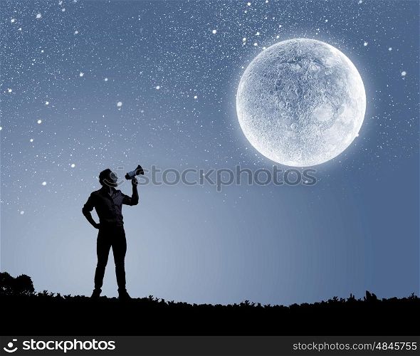 Man with trumpet. Silhouette of man screaming in trumpet at night