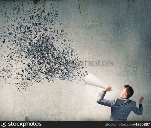 Man with trumpet. Young businessman screaming emotionally in paper trumpet