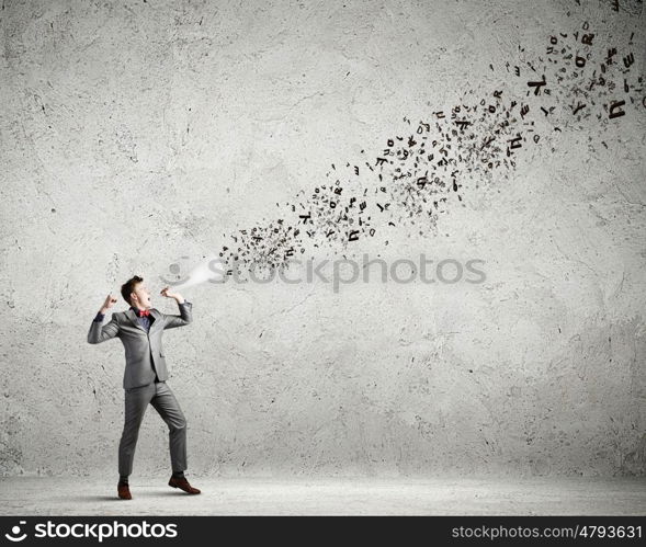 Man with trumpet. Young excited businessman screaming in paper trumpet