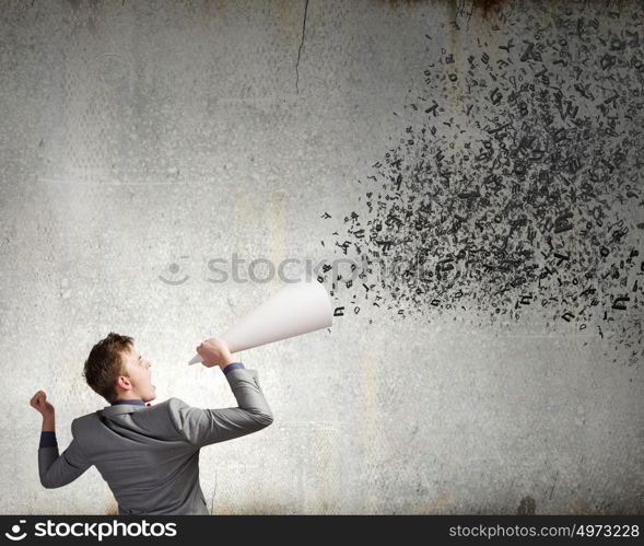 Man with trumpet. Young excited businessman screaming in paper trumpet