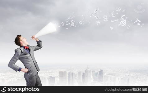 Man with trumpet. Young excited businessman screaming in paper trumpet