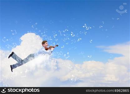 Man with violin. Young businessman flying in sky and playing violin