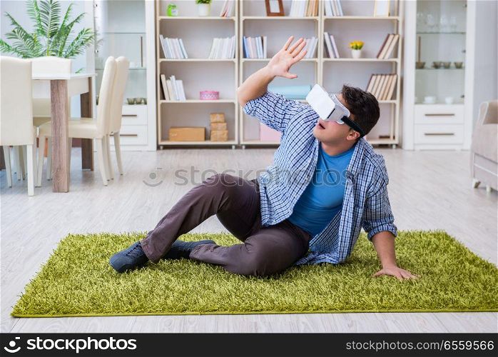Man with virtual reality glasses playing at home