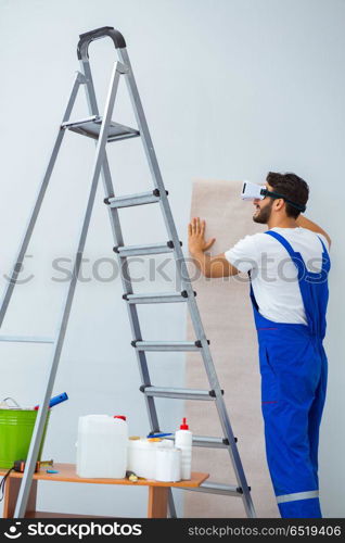 Man with VR glasses gluing wallpaper